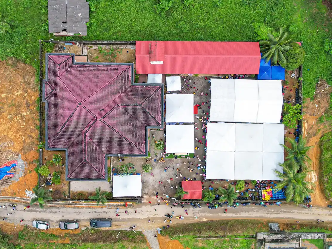 Vue aérienne d'une propriété aux toitures colorées au milieu de la végétation